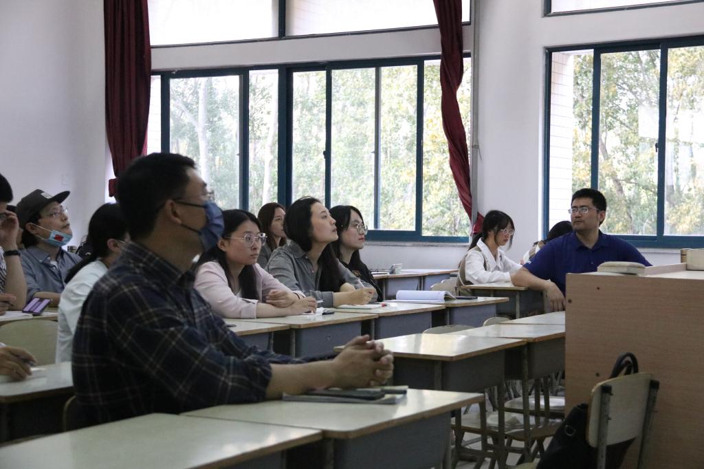 一群人坐在桌子前描述已自动生成 一群人坐在桌子前描述已自动生成