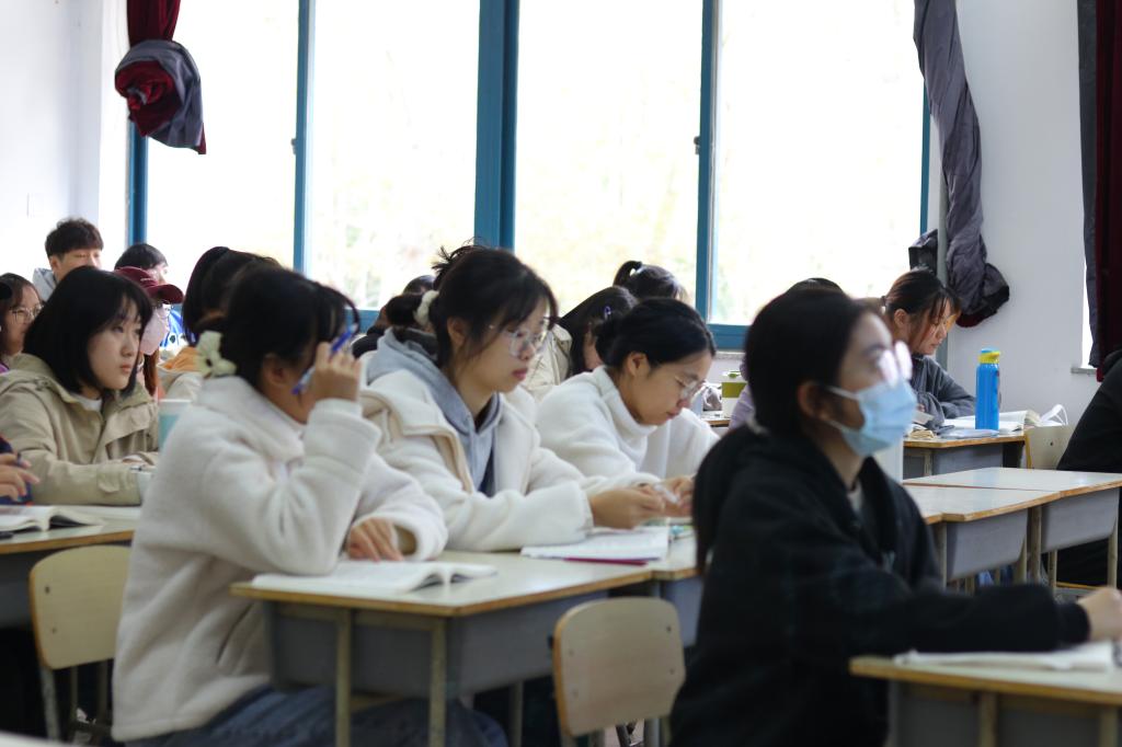 一群人坐在桌子前描述已自动生成 一群人坐在桌子前描述已自动生成