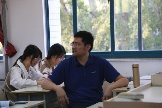 桌子前坐着的人低可信度描述已自动生成 桌子前坐着的人低可信度描述已自动生成